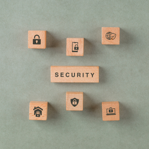 Security concept with wooden blocks with icons on sage color background flat lay. horizontal image